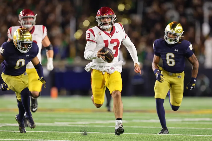 Caleb Williams of the USC Trojans runs with the ball as we make our best Utah-USC prediction.