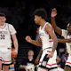 Jaylin Stewart #3, Hassan Diarra #10 and Donovan Clingan #32 of the Connecticut Huskies react as we look at which teams have a chance to win March Madness ahead of the 2024 NCAA Tournament.