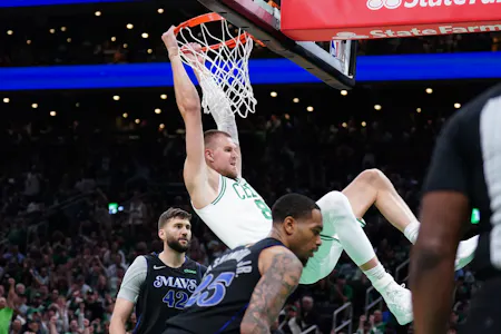 Boston Celtics center Kristaps Porzingis dunks against Dallas Mavericks forward P.J. Washington and forward Maxi Kleber as we dive into the best player props for Sunday's Game 2 of the NBA Finals.  