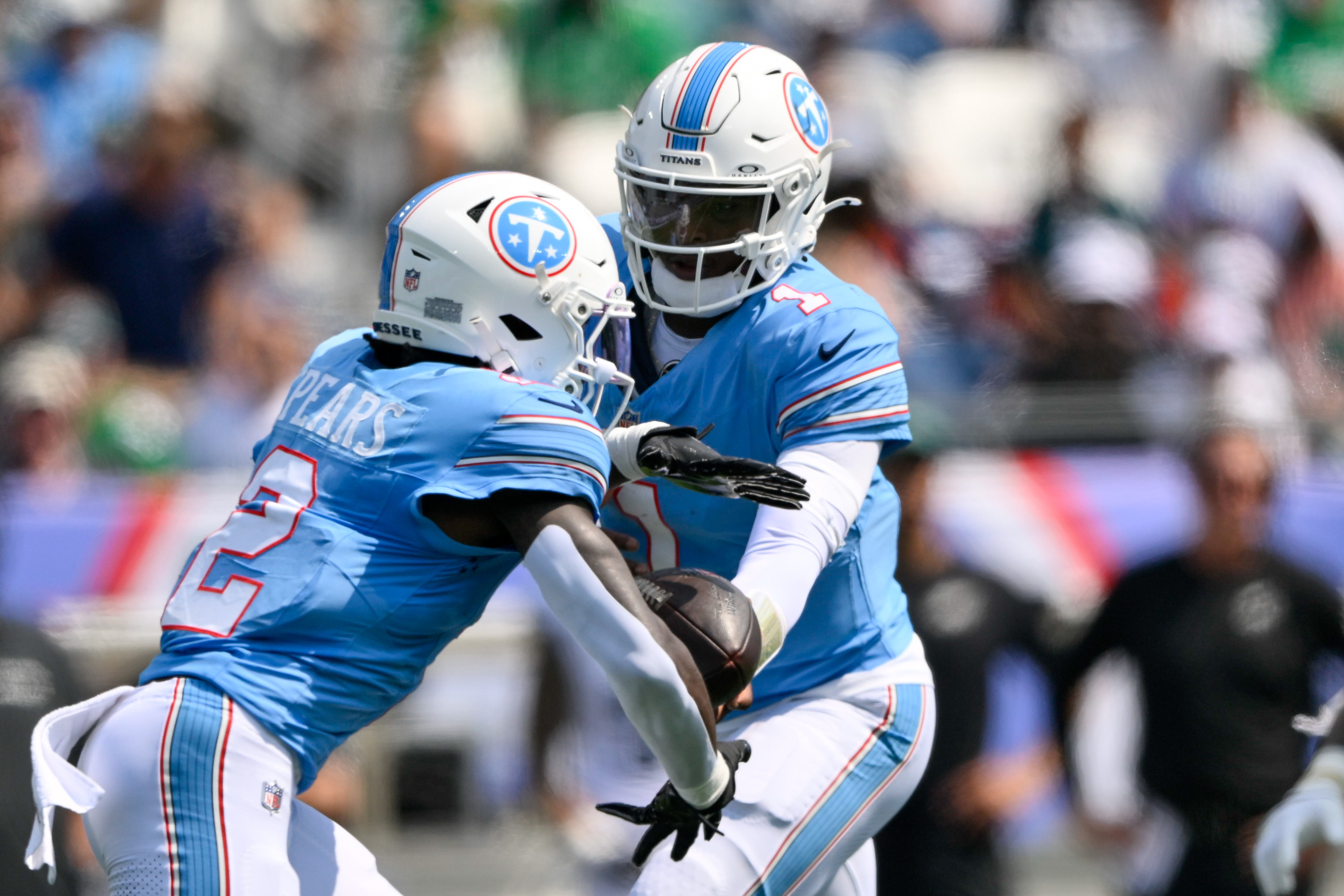 Tennessee Titans quarterback Cam Ward (1) hands the ball off as he is featured in our Titans vs. Giants prediction.