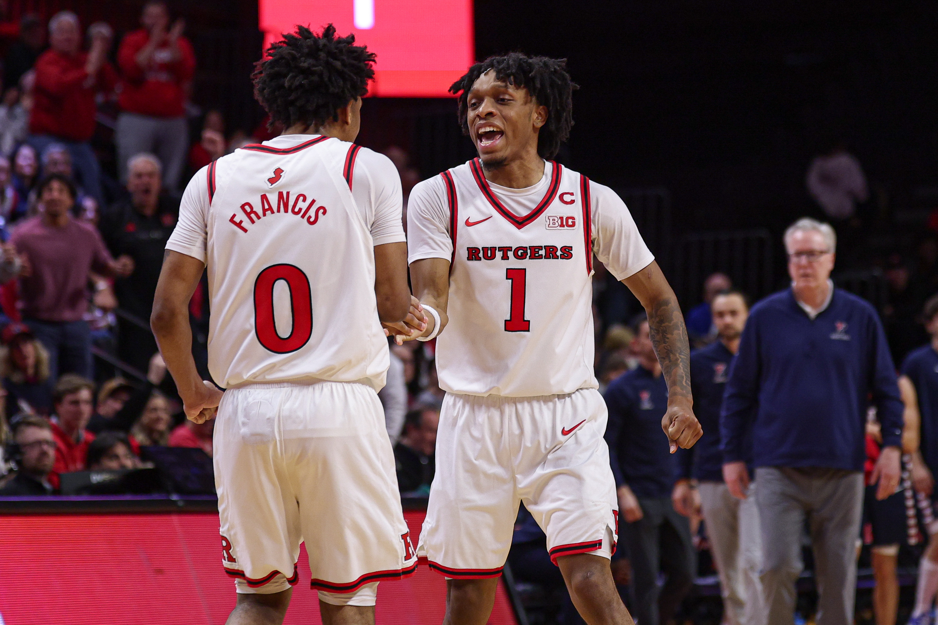 Rutgers Scarlet Knights guard Tariq Francis (0) and guard Jamichael Davis (1) celebrate as we dive into our college basketball best bets today.