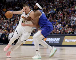 Nikola Jokic of the Denver Nuggets drives to the basket against Precious Achiuwa of the New York Knicks. Jokic is the runaway favorite by the NBA MVP odds. 