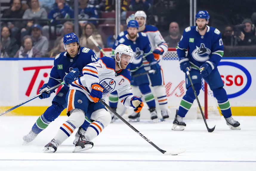 Vancouver Canucks forward Kiefer Sherwood defends against Edmonton Oilers forward Connor McDavid as we offer our Jets vs. Oilers prediction.