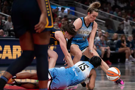 Chicago Sky guard Marina Mabrey (4), Lindsay Allen (15), and Indiana Fever guard Caitlin Clark (22) reach for a loose ball, as we offer our best Fever vs. Sky prediction for Sunday's WNBA matchup at Wintrust Arena in Chicago.