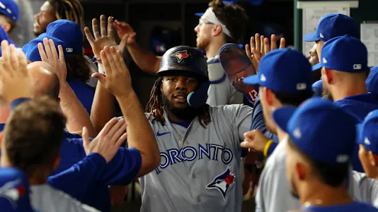 Vladimir Guerrero Jr. is greeted in the dugout after scoring on a two-run home run by Bo Bichette.