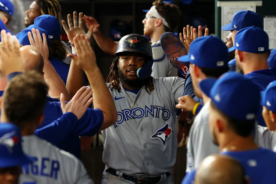 Vladimir Guerrero Jr. is greeted in the dugout after scoring on a two-run home run by Bo Bichette.