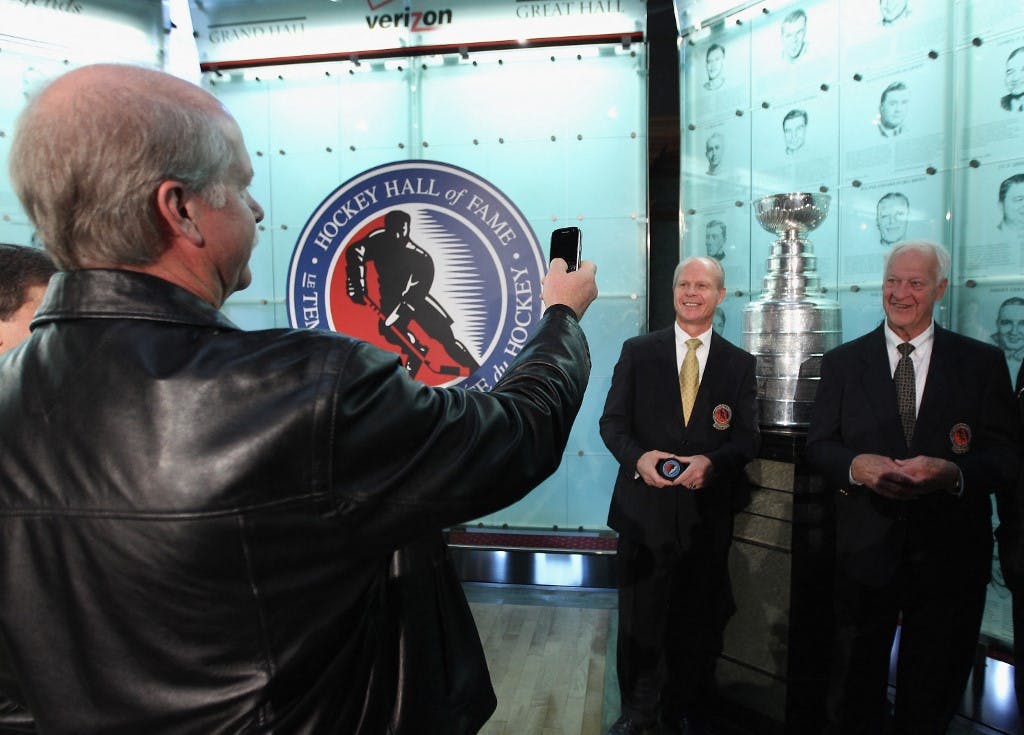 Marty Howe (L) takes a photo of his brother and father, 2011 Hall of Fame inductee Mark Howe and hockey legend Gordie Howe during a photo opportunity at the Hockey Hall Of Fame on November 14, 2011 in Toronto, Ontario, Canada.