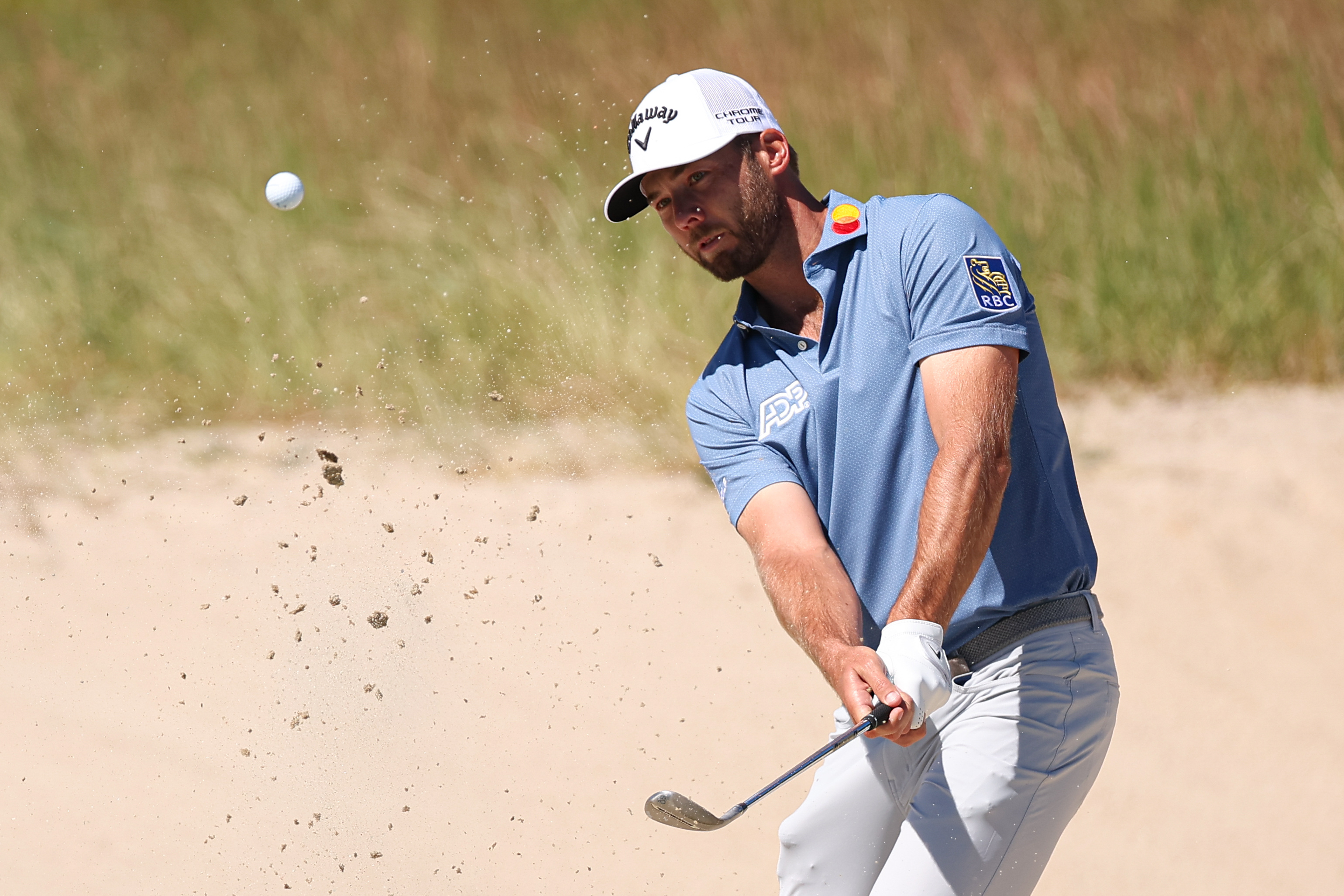 Sam Burns plays a bunker shot on hole 2 as he is featured in our U.S. Open picks.
