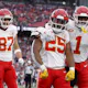 Travis Kelce #87, Clyde Edwards-Helaire #25, and Jerick McKinnon #1 of the Kansas City Chiefs celebrate as we look at our anytime touchdown scorer predictions for the 2024 Super Bowl.