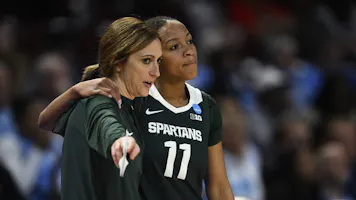 Head coach Robyn Fralick speaks with Jocelyn Tate #11 of the Michigan State Spartans as we look at the Michigan sports betting financials for February 2024.