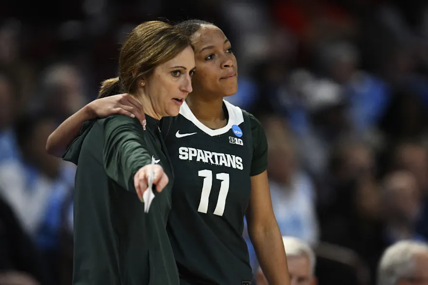 Head coach Robyn Fralick speaks with Jocelyn Tate #11 of the Michigan State Spartans as we look at the Michigan sports betting financials for February 2024.