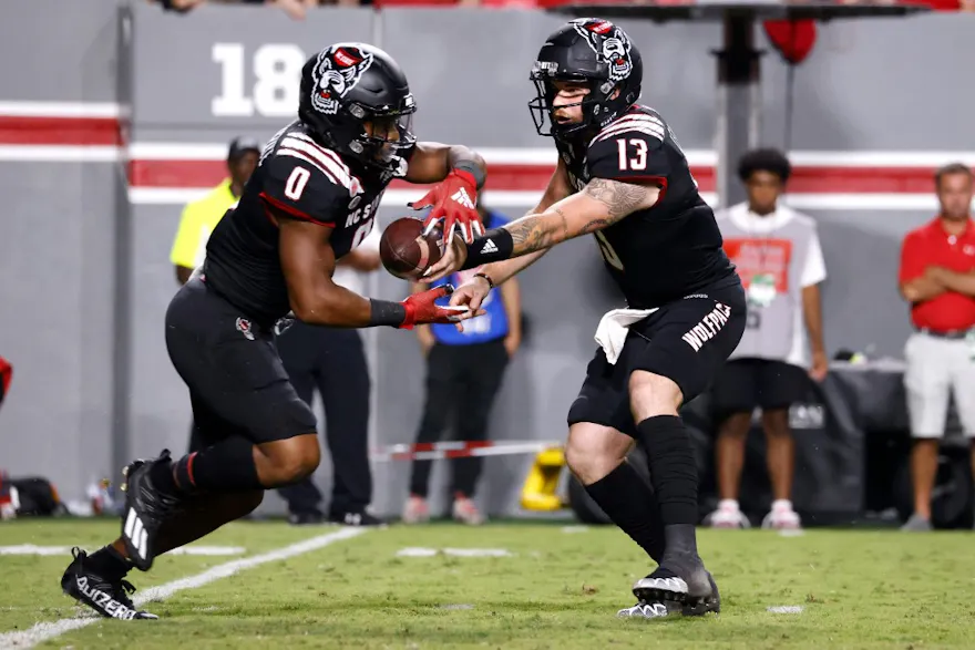 Devin Leary #13 of the NC State Wolfpack hands off to teammate Demie Sumo-Karngbaye #0 during the second half of their game against the Texas Tech Red Raiders at Carter-Finley Stadium on September 17, 2022 in Raleigh, North Carolina.