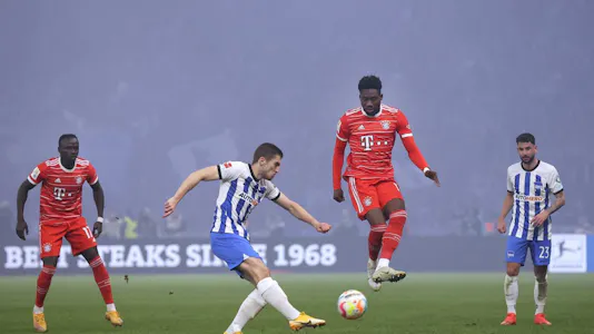 Hertha Berlin's Jonjoe Kenny and Bayern Munich's Alphonso Davies vie for the ball.