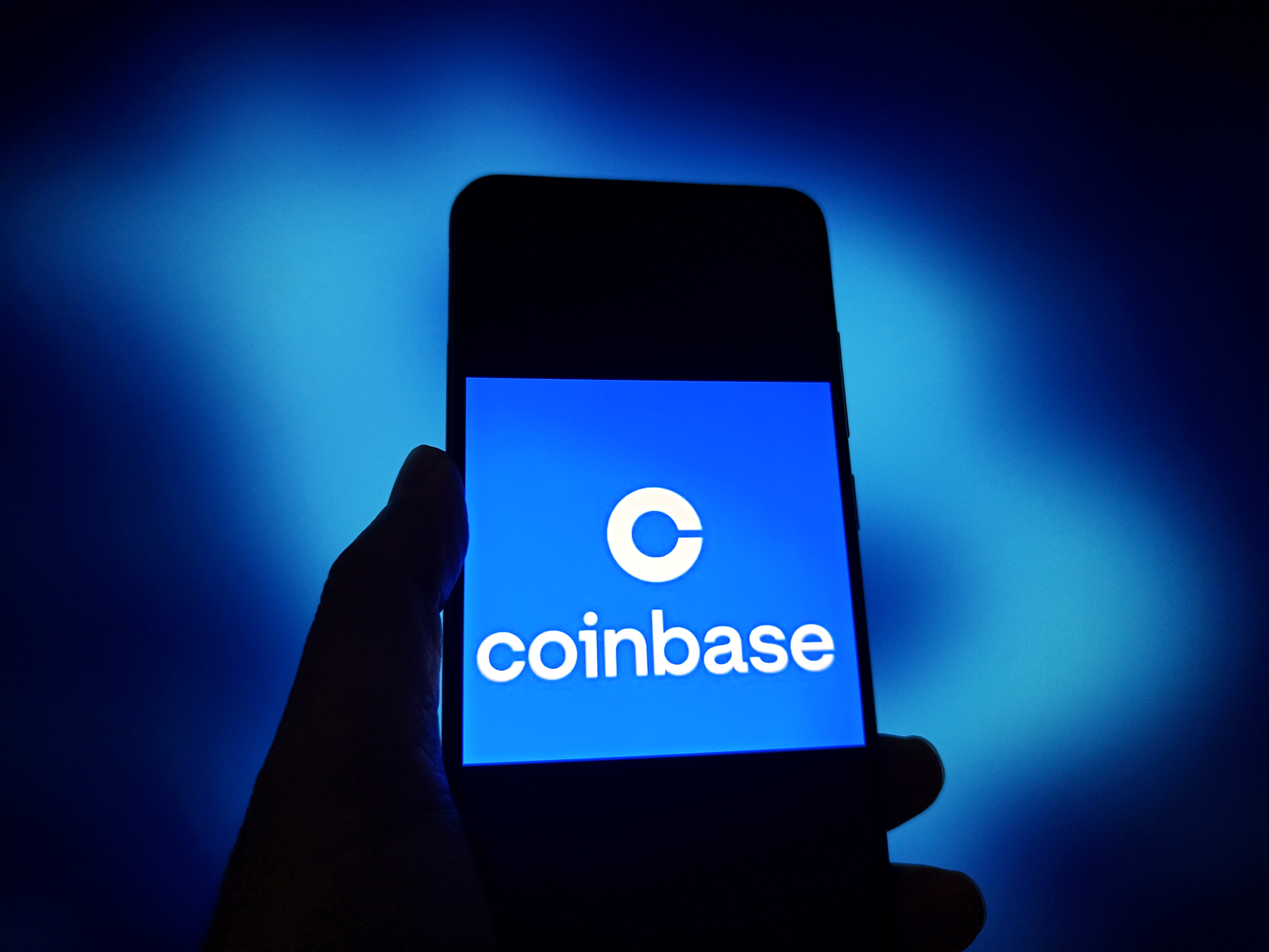 A Coinbase logo on a smartphone as we look at the company's statement that a federal tax rule change could boost prediction markets.