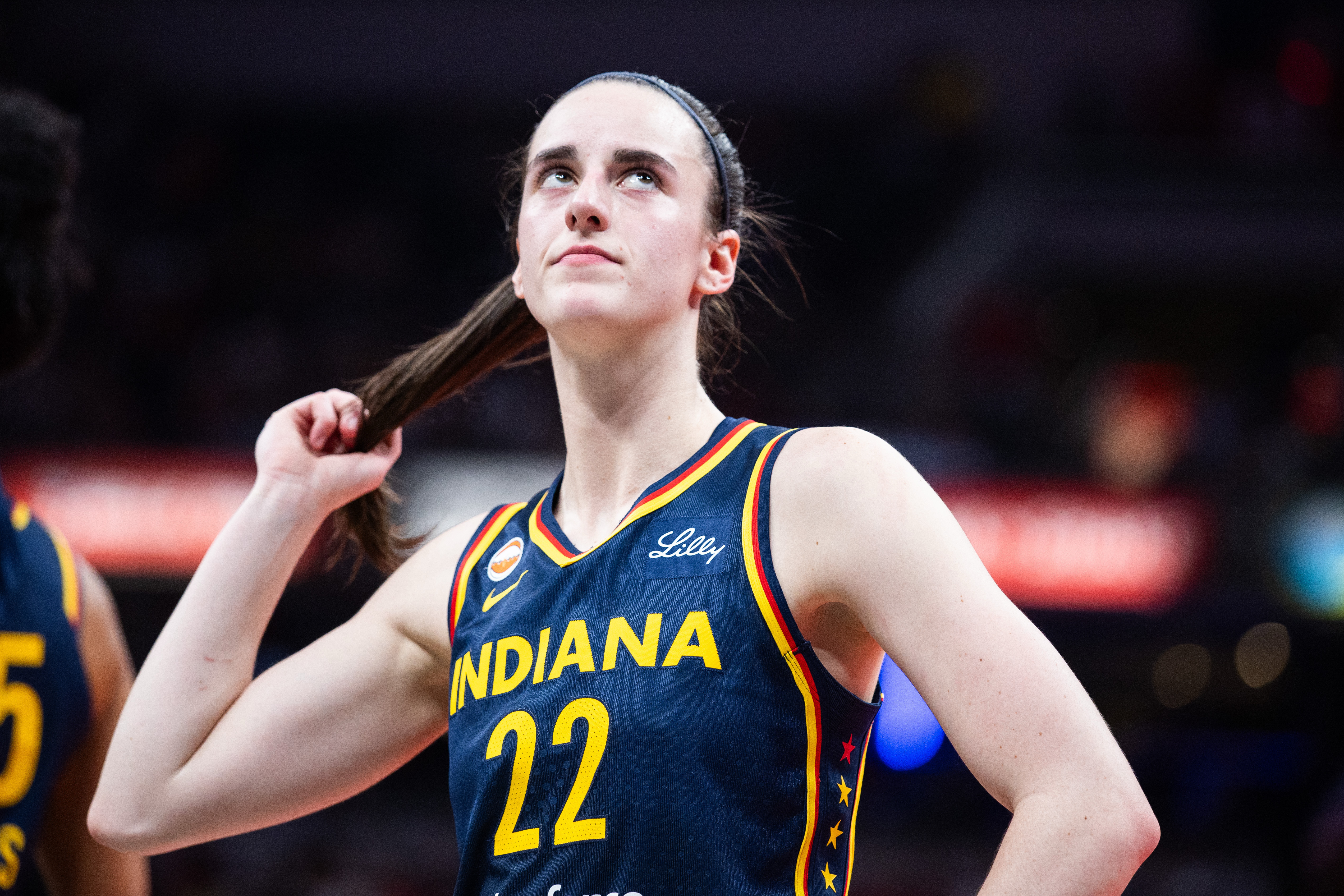 Indiana Fever guard Caitlin Clark (22), seen here looking on during a game, is featured in our Fever vs. Sun prediction.