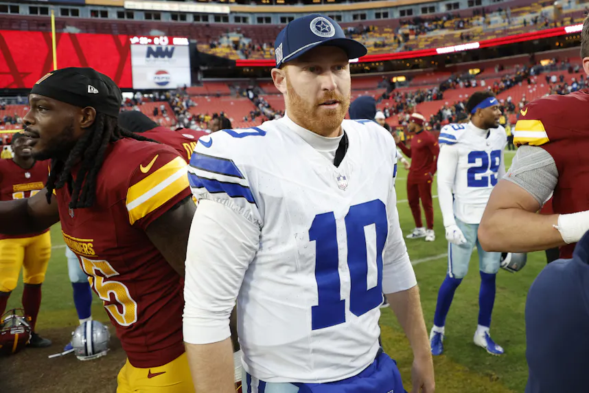 Dallas Cowboys quarterback Cooper Rush walks off the field after shaking hands with Washington Commanders players as we look at our Bengals vs. Cowboys parlay picks.
