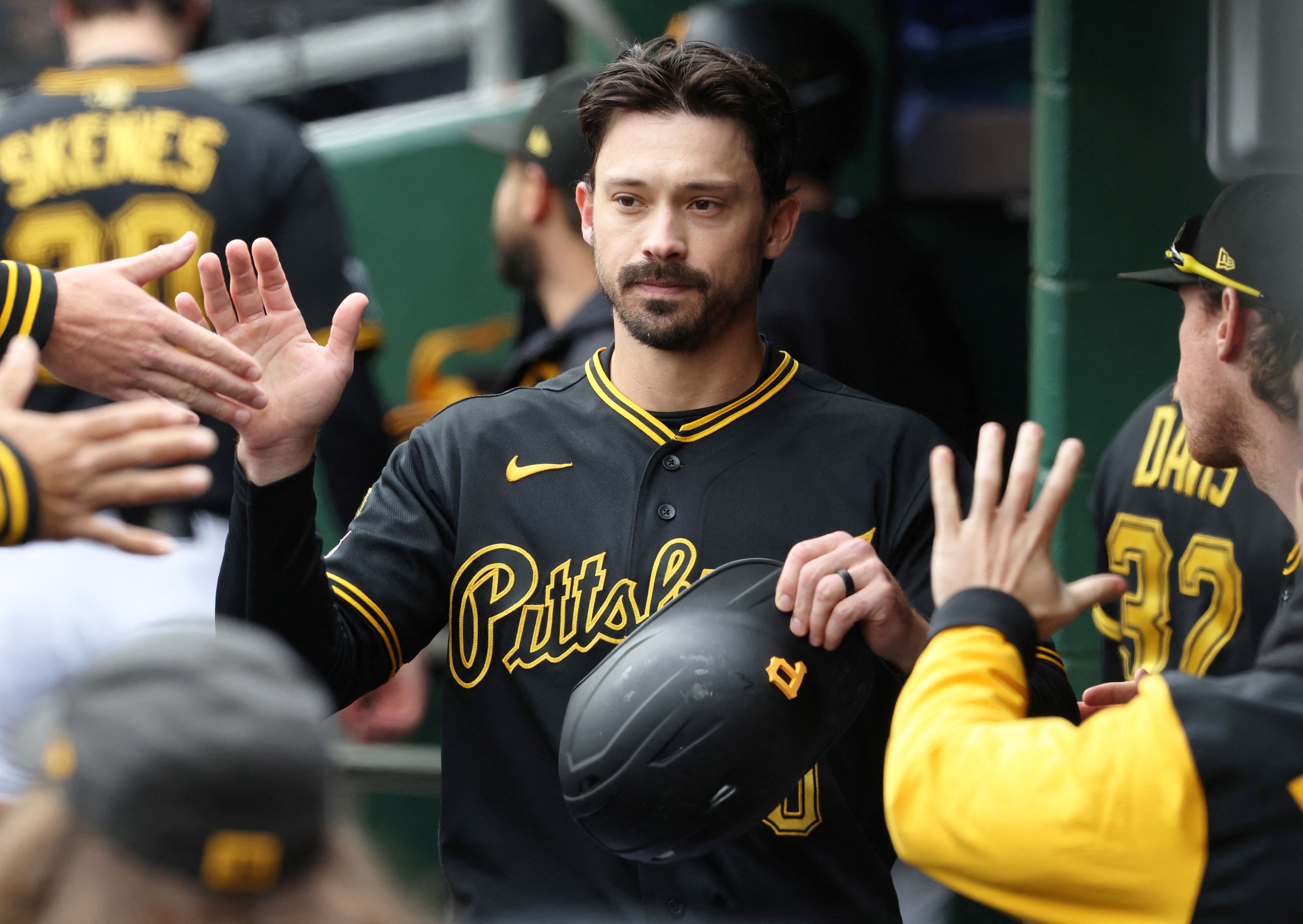 Pittsburgh Pirates right fielder Bryan Reynolds high-fives in the dugout, and he's featured in our Reds vs. Pirates prediction.