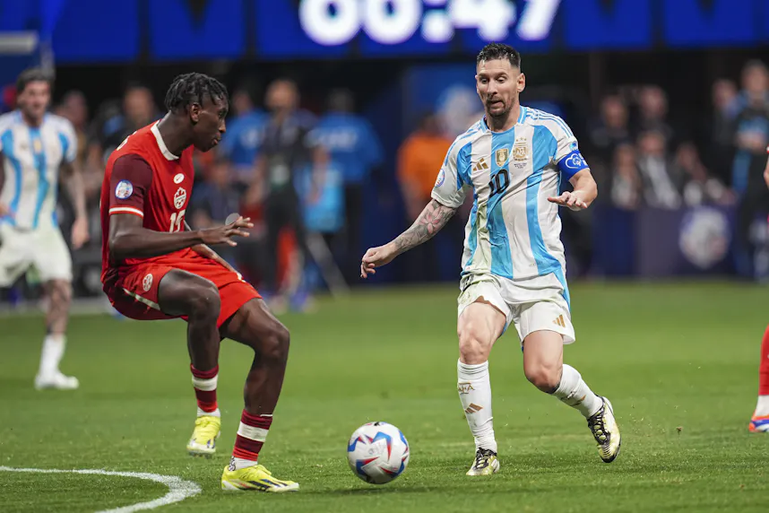 Argentina forward Lionel Messi ( plays the ball against Canada defender Moise Bombito as we look at our best Argentina vs. Canada prediction