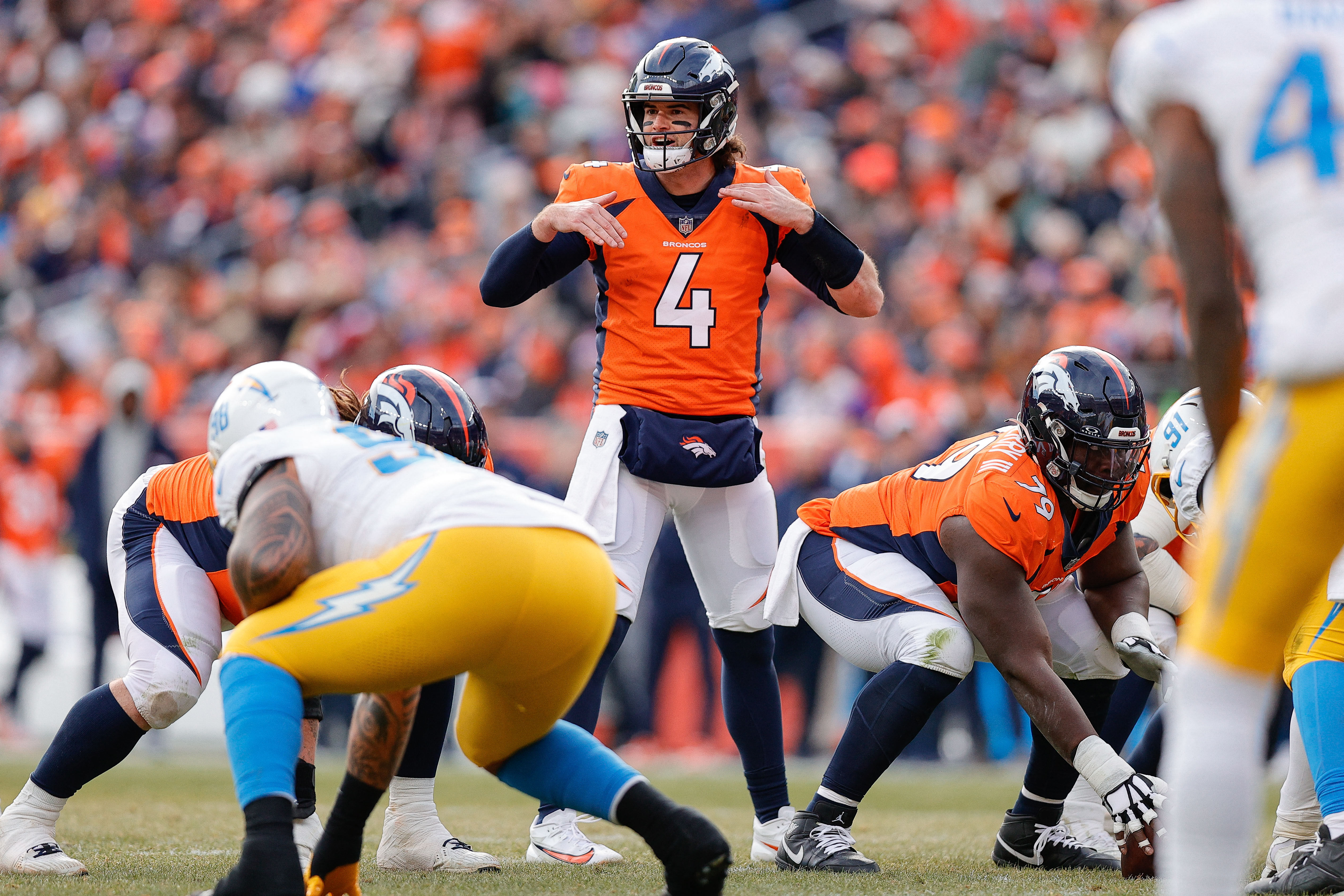 Denver Broncos quarterback Jarrett Stidham motions at the line of scrimmage as we make our best Jarrett Stidham player prop bets for the AFC Championship Game.