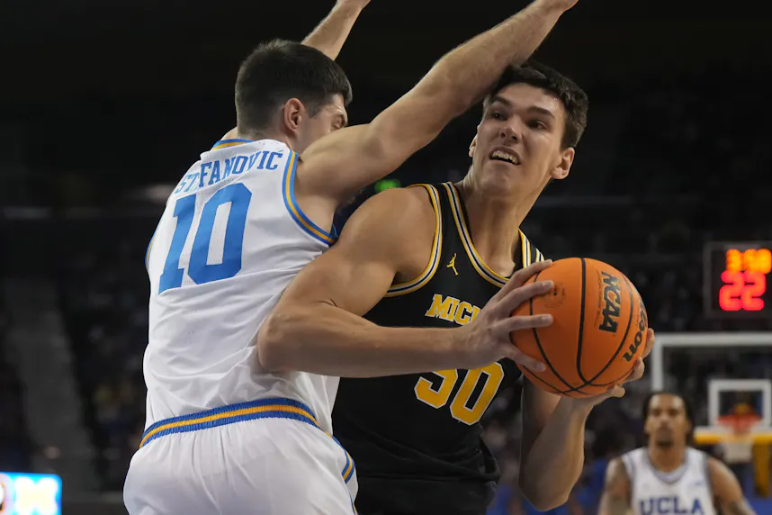 Michigan Wolverines center Vladislav Goldin shoots the ball against UCLA Bruins guard Lazar Stefanovic as we look at our Michigan vs. Purdue prediction.