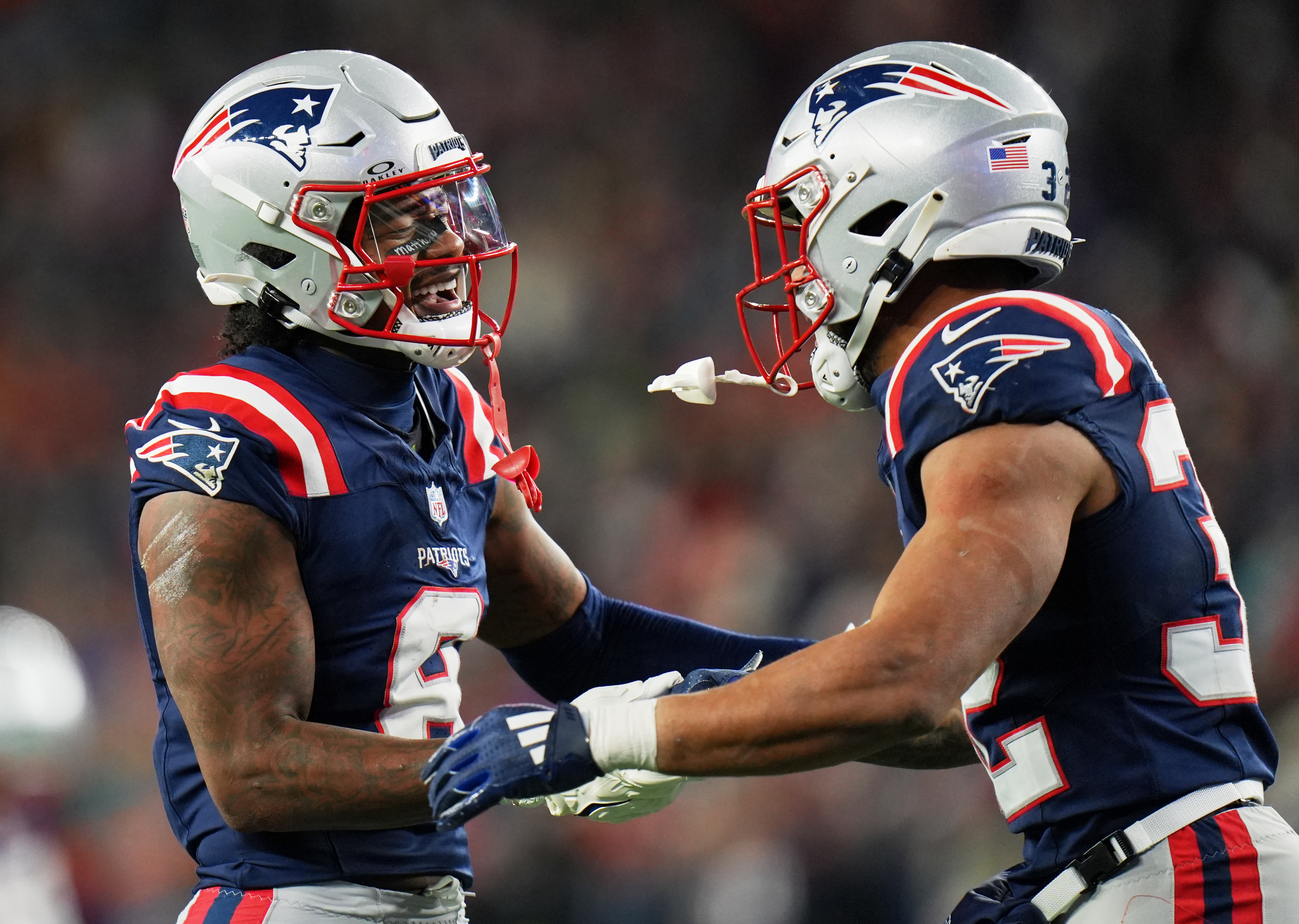 New England Patriots wide receiver Stefon Diggs (8), who is featured in our NFL AI predictions for the Conference Championships, celebrates with running back TreVeyon Henderson (32).