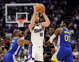 Domantas Sabonis of the Sacramento Kings is guarded by Chris Paul and Jonathan Kuminga of the Golden State Warriors in the second half during the Play-In Tournament. We're backing Sabonis in our Kings vs. Pelicans player props. 