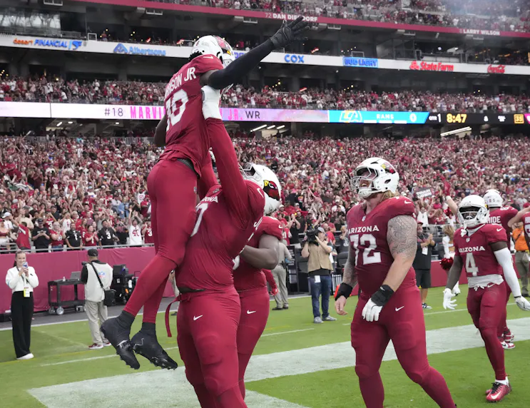 Arizona Cardinals offensive tackle Paris Johnson Jr. lifts wide receiver Marvin Harrison Jr., who soared to the top of the Offensive Rookie of the Year odds leaderboard after a sensational Week 2 performance.