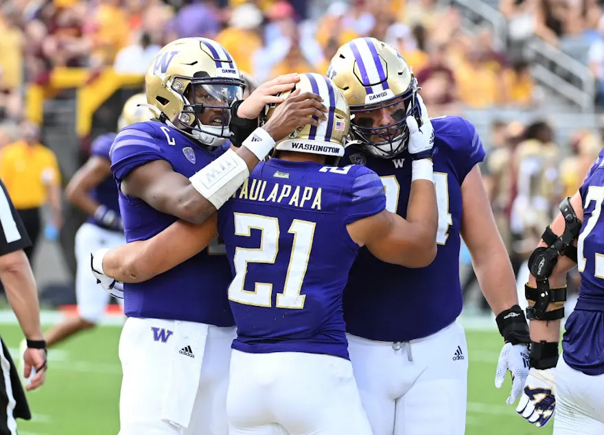 Wayne Taulapapa of the Washington Huskies celebrates with Michael Penix Jr. and Corey Luciano after scoring a rushing touchdown against the Arizona State Sun Devils.