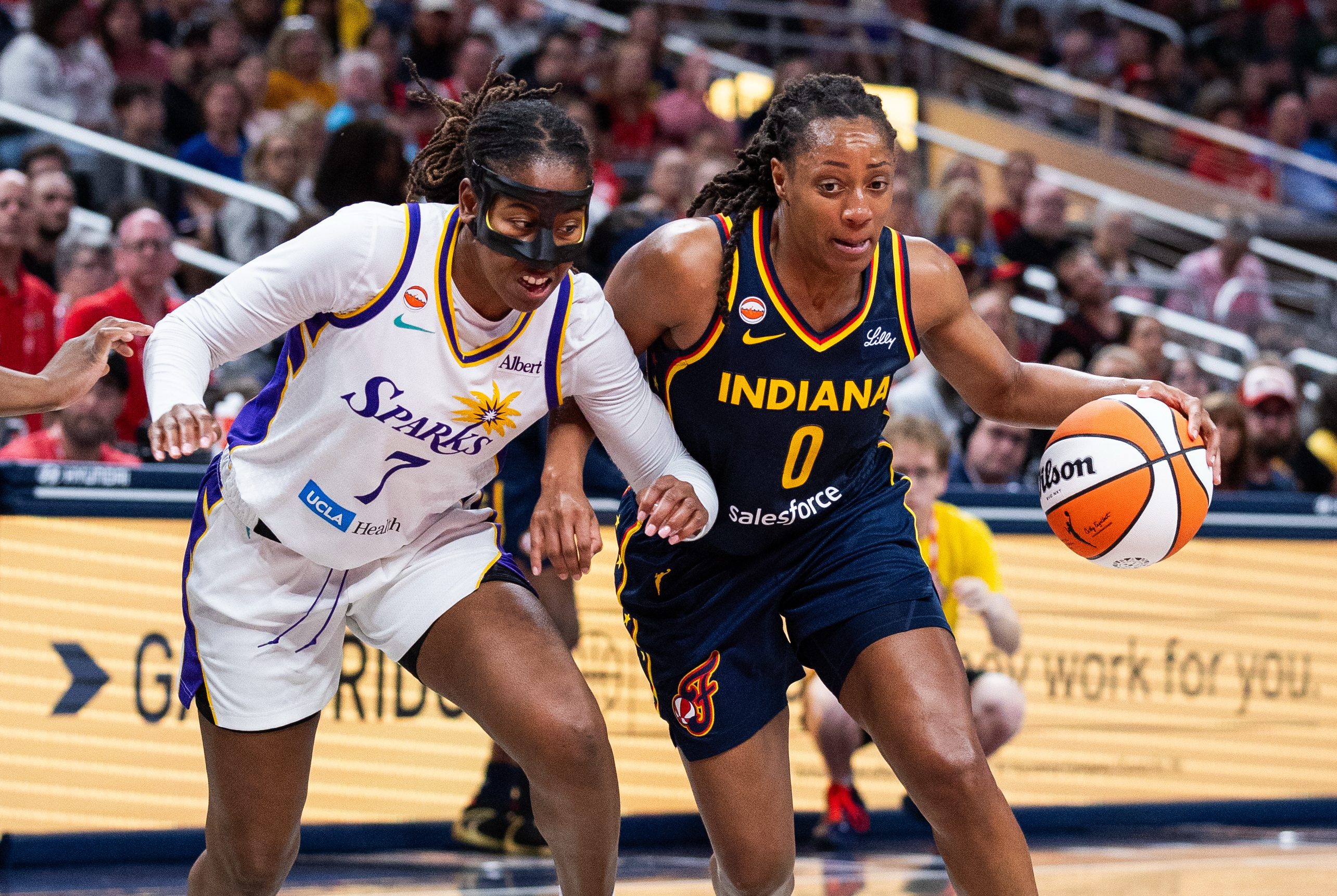 Indiana Fever guard Kelsey Mitchell (0) dribbles against Los Angeles Sparks guard Ariel Atkins (7) as we break down our Fever vs. Sparks prediction.