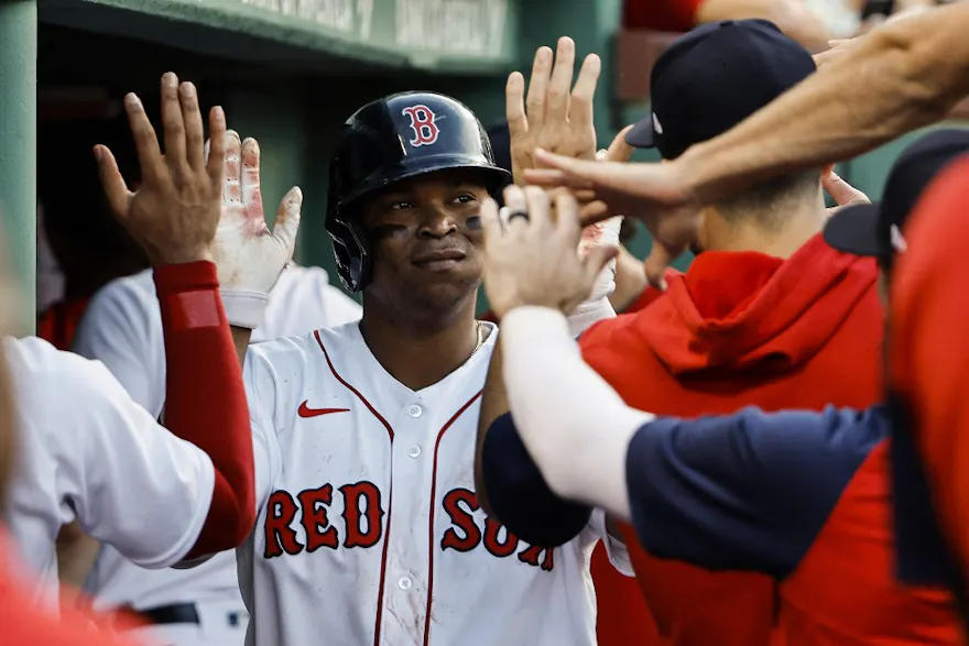 Rafael Devers of the Boston Red Sox is congratulated in the dugout after scoring a run against the Texas Rangers.