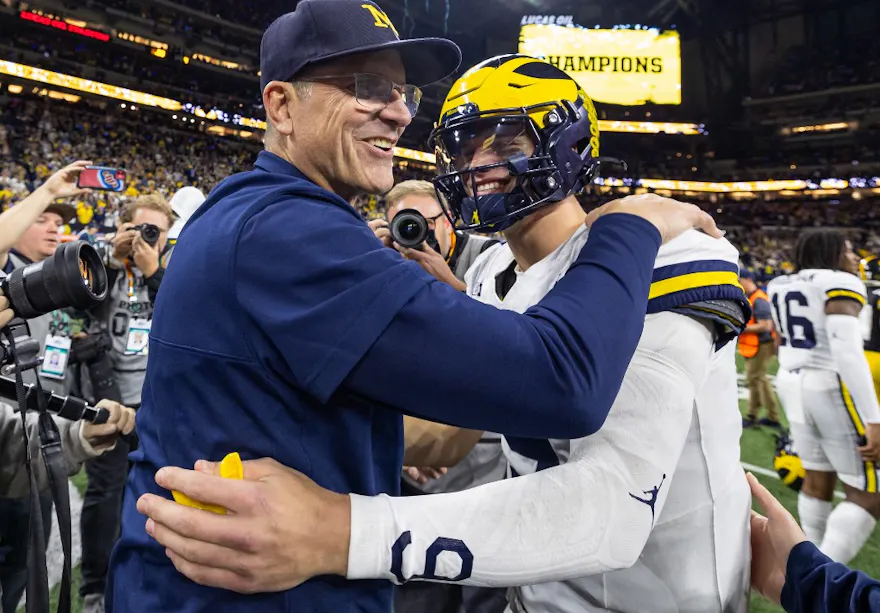 Head coach Jim Harbaugh celebrates with J.J. McCarthy of the Michigan Wolverines after winning the Big Ten Championship against the Iowa Hawkeyes as we look at our Washington-Michigan prediction.