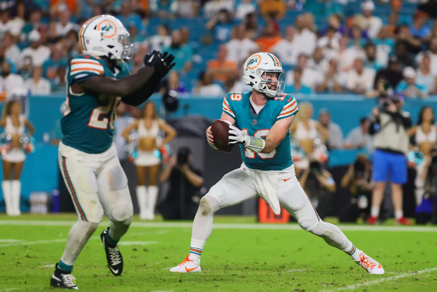 Miami Dolphins quarterback Skylar Thompson fakes a handoff to running back De'Von Achane as we offer our Titans vs. Dolphins MNF parlay.
