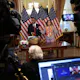 Journalists look on as Speaker of the House Nancy Pelosi (D-CA) presents Rep. Emanuel Cleaver (D-MO) with a basket with items from the San Francisco area, including Ghirardelli chocolate, to settle their friendly wager on the Super Bowl.