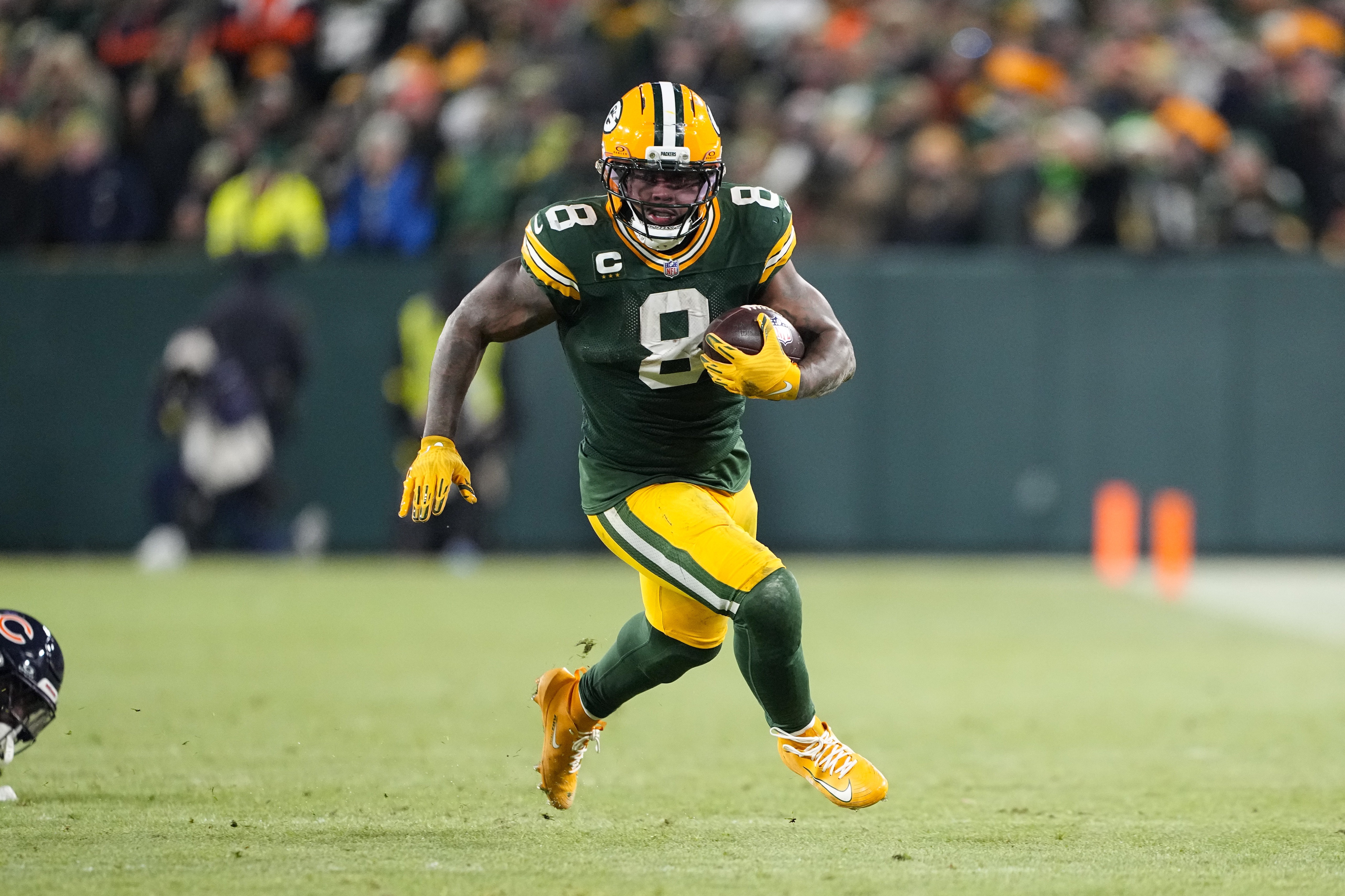 Green Bay Packers running back Josh Jacobs (8) runs with the football as we provide our Panthers vs. Packers player props for Thursday Night Football.