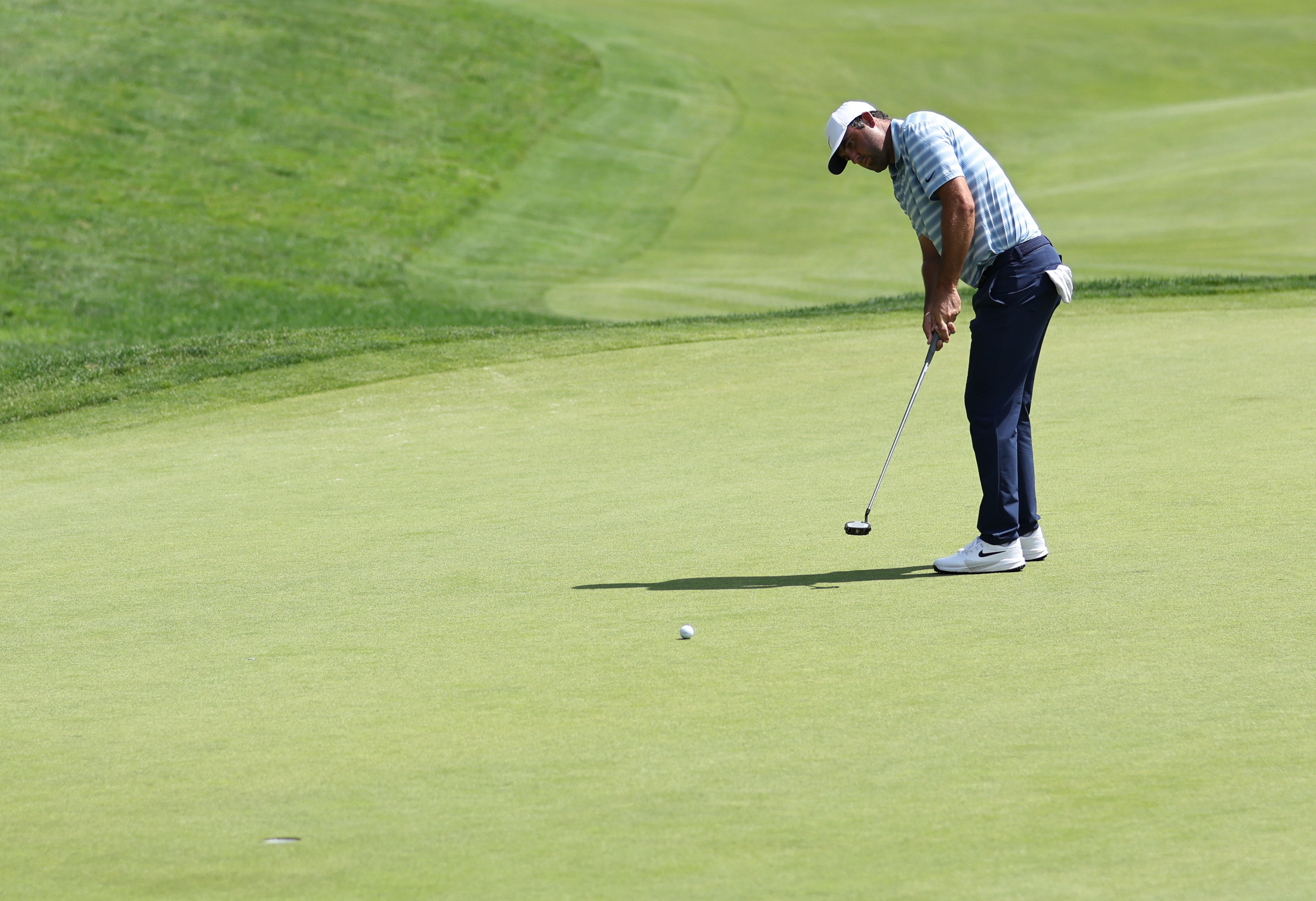 Scottie Scheffler 18th green putt as he is featured in our Travelers Championship Third-Round leader prediction & odds.