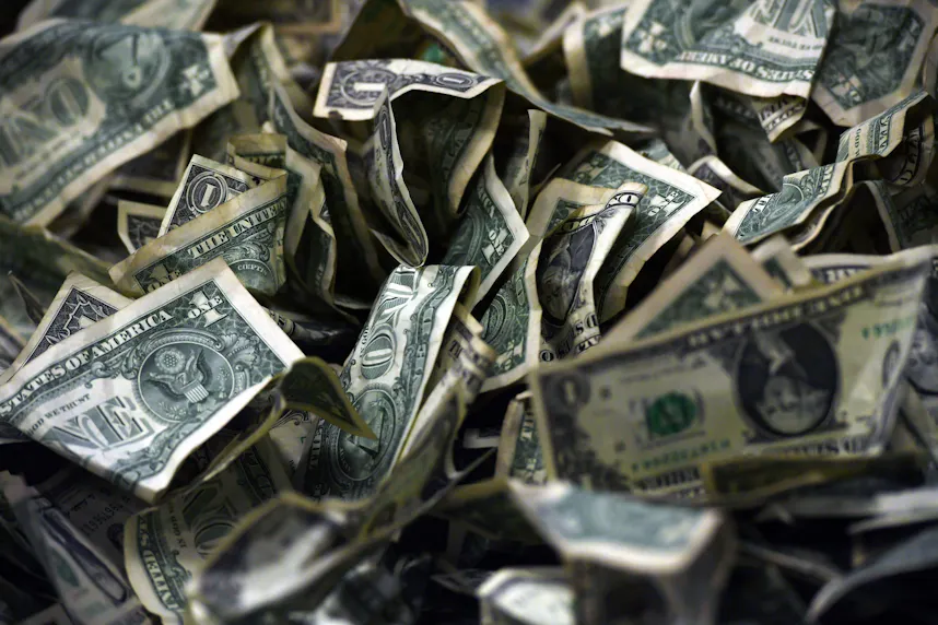 A pile of dollar bills sits on a table as we look at the details of a new PrizePicks game called Streak.