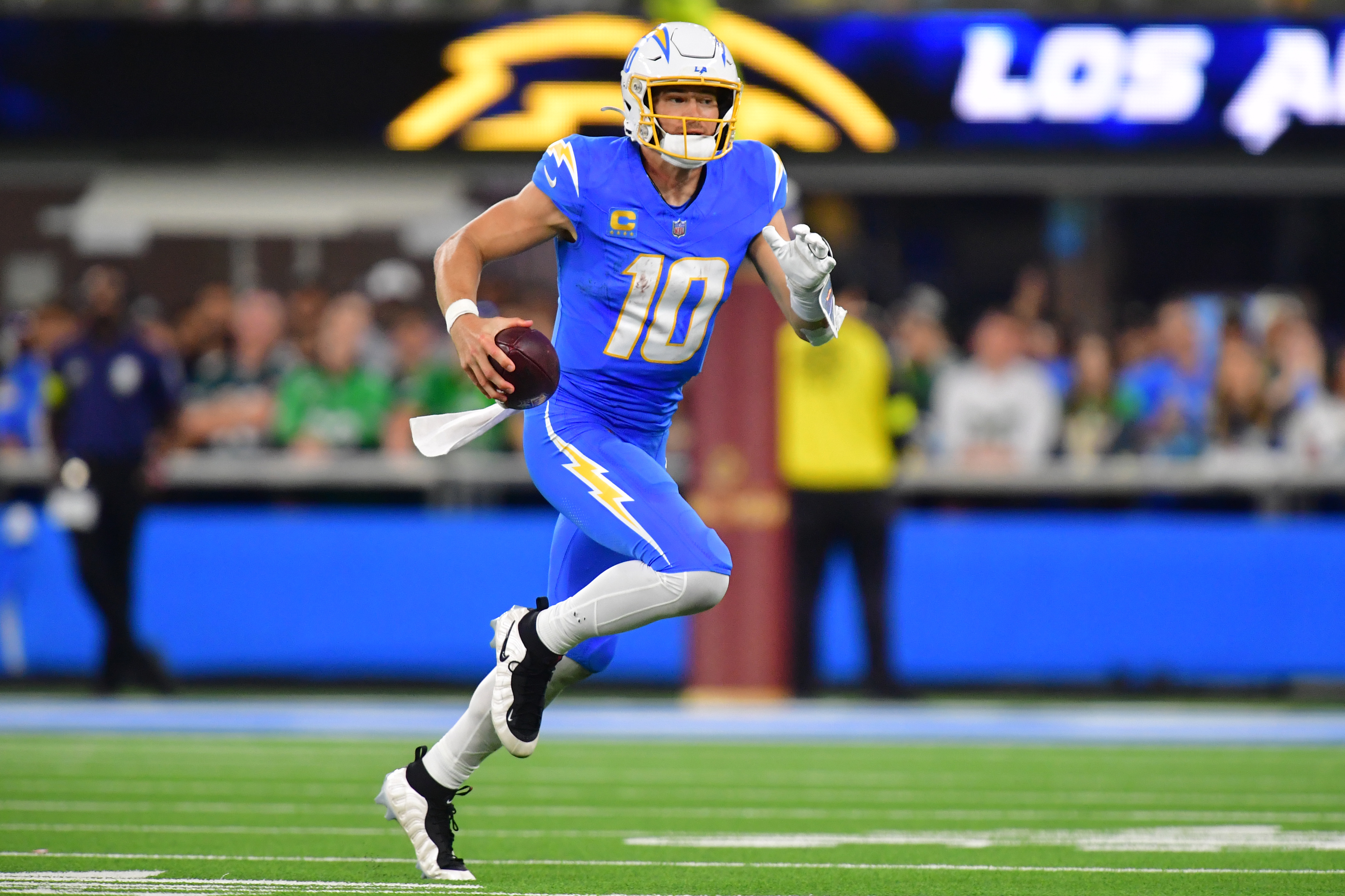 Los Angeles Chargers quarterback Justin Herbert (10) runs as we offer our Texans vs. Chargers same-game parlay.