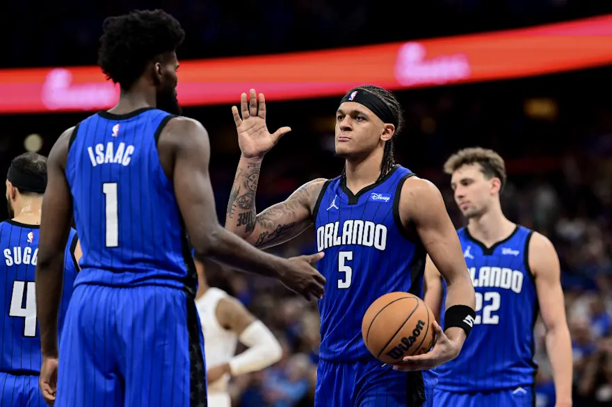 Paolo Banchero (5) of the Orlando Magic high-fives teammate Jonathan Isaac (1) after a play against the Cleveland Cavaliers, as we offer our best Magic vs. Cavaliers player props for Game 7 on Sunday at Rocket Mortgage FieldHouse in Cleveland.