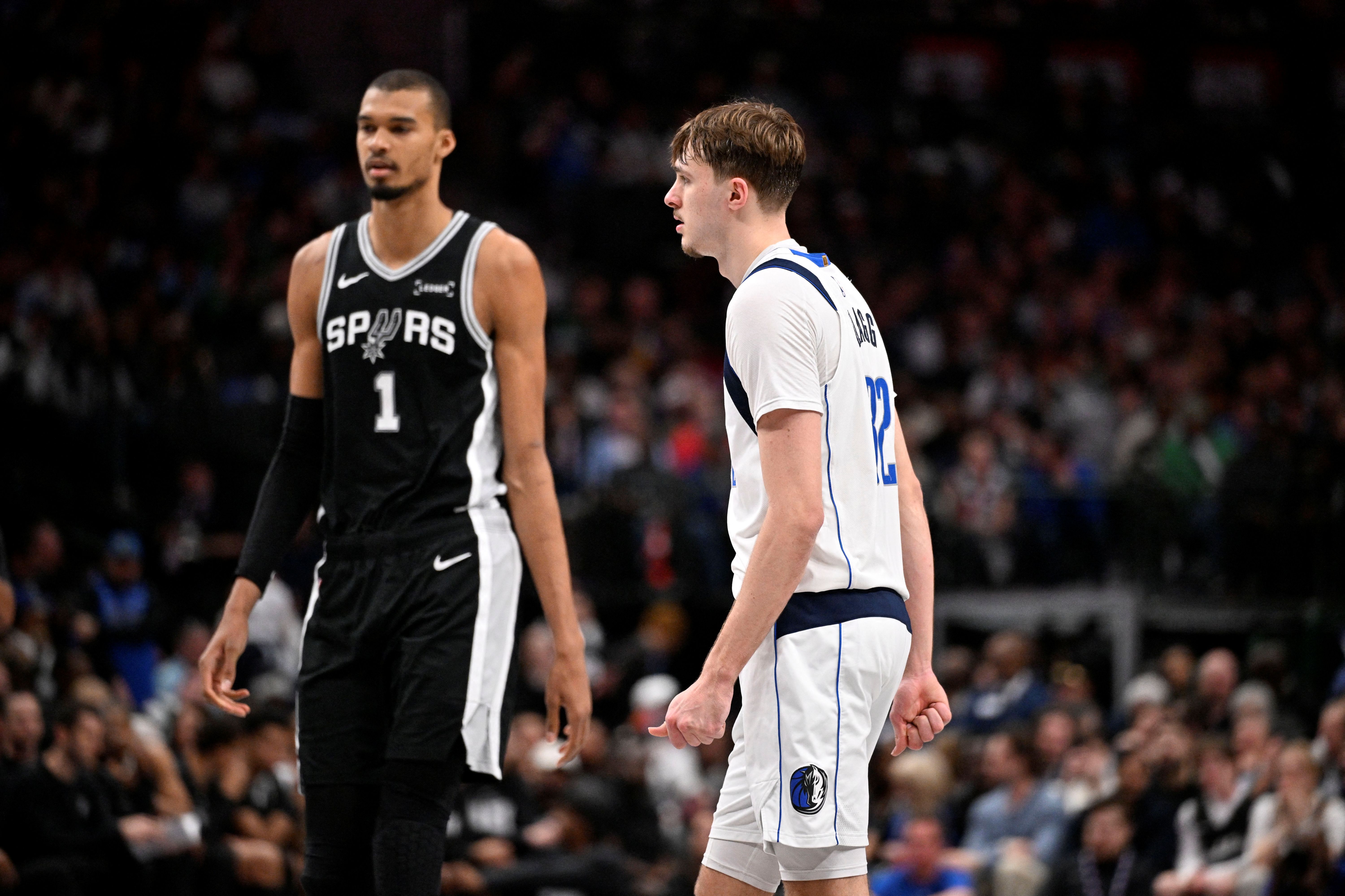 San Antonio Spurs forward Victor Wembanyama (1) walks past Dallas Mavericks forward Cooper Flagg (32), and both are featured in our Mavericks vs. Spurs player props today.