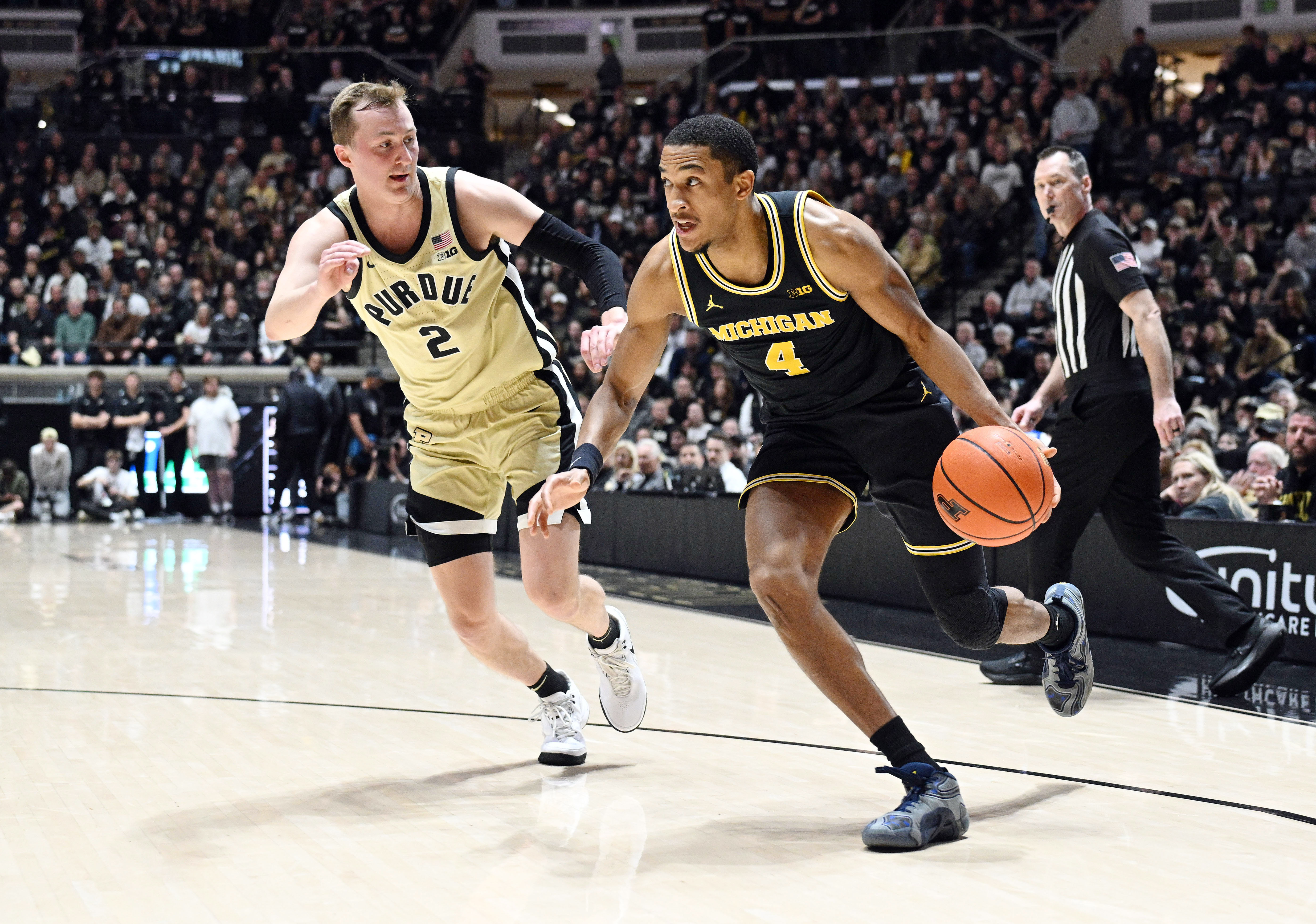 Michigan Wolverines guard Nimari Burnett drives the ball around Purdue Boilermakers guard Fletcher Loyer as we make our best Purdue vs. Michigan prediction.