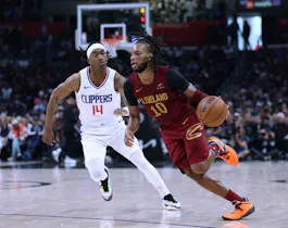 Darius Garland of the Cleveland Cavaliers dribbles past Terance Mann of the LA Clippers during a 120-118 Clippers win at Crypto.com Arena. We're backing Garland in our Magic vs. Cavaliers player props & odds. 
