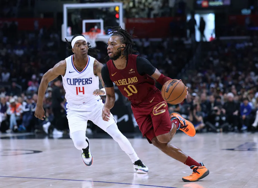 Darius Garland of the Cleveland Cavaliers dribbles past Terance Mann of the LA Clippers during a 120-118 Clippers win at Crypto.com Arena. We're backing Garland in our Magic vs. Cavaliers player props & odds. 