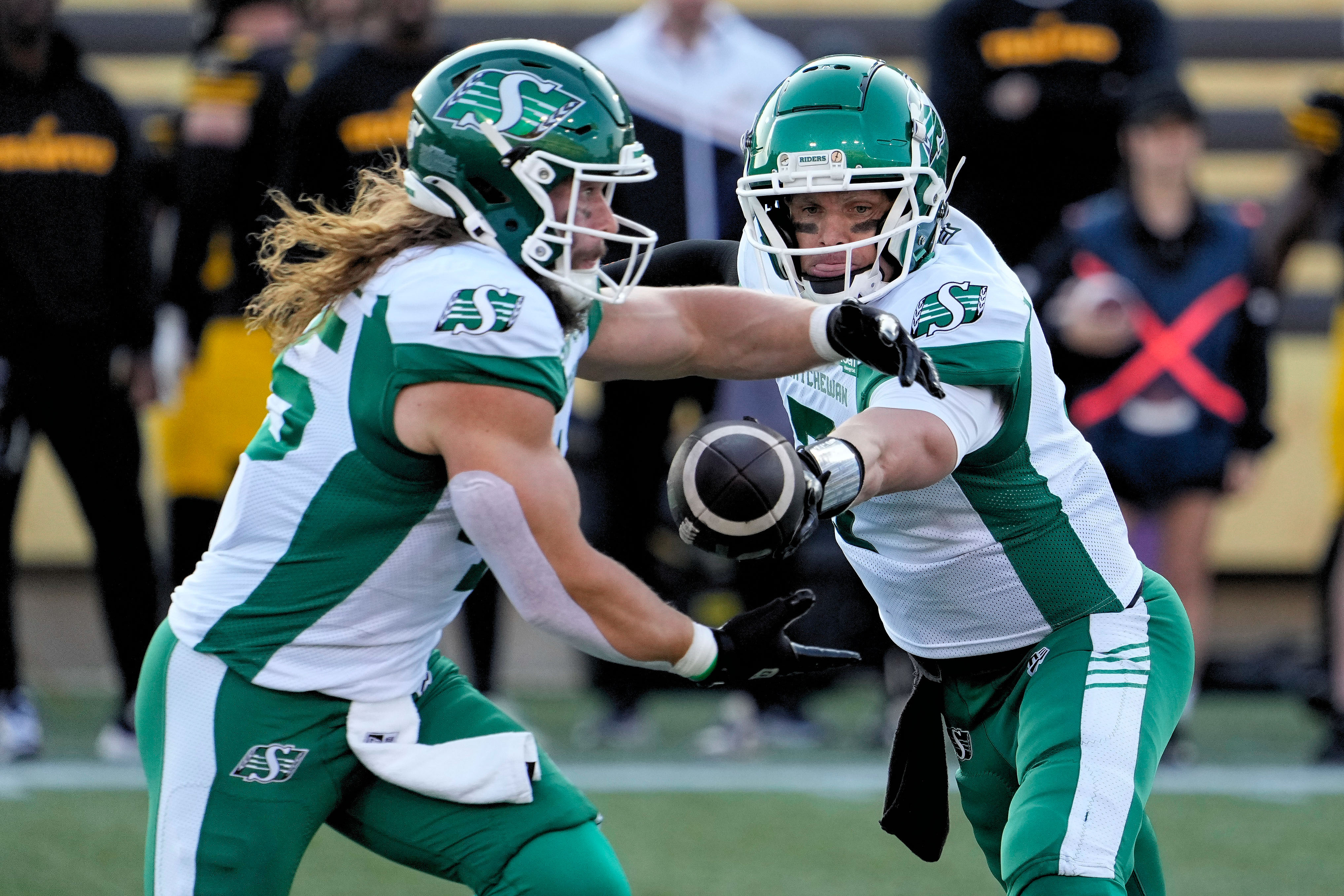 Saskatchewan Roughriders quarterback Trevor Harris (7) hands the ball off to running back A.J. Ouellette (45) as we provide our Alouettes vs. Roughriders prediction for the 112th Grey Cup