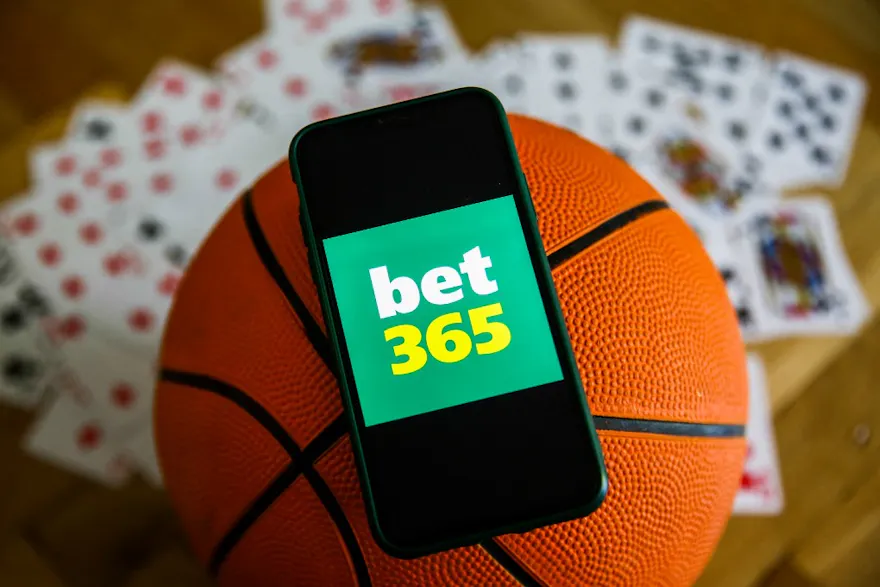 bet365 logo displayed on a mobile phone, basketball, and playing cards are seen in this illustration photo as we look at our bet365 Arizona bonus code.