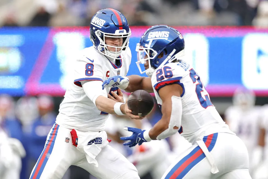 Daniel Jones of the New York Giants hands the ball off to Saquon Barkley in the fourth quarter of the game against the Philadelphia Eagles at MetLife Stadium on November 28, 2021 in East Rutherford, New Jersey.