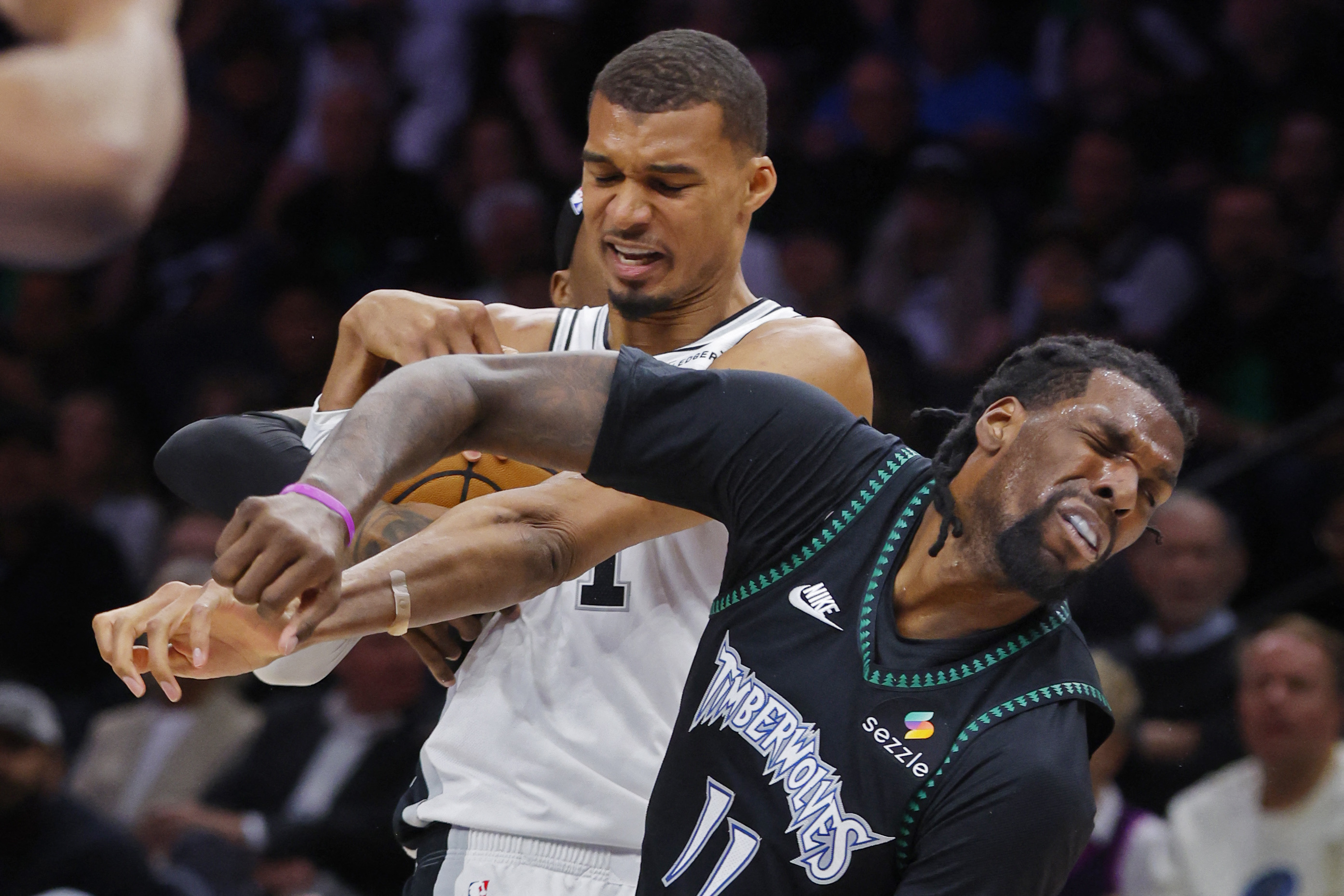 San Antonio Spurs center Victor Wembanyama (1) commits a foul against Minnesota Timberwolves center Naz Reid (11), and both are featured in our Timberwolves vs. Spurs player props for Game 5 today.