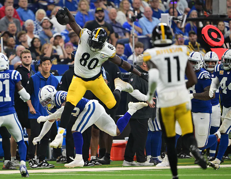 Pittsburgh Steelers tight end Darnell Washington hurdles Indianapolis Colts safety Nick Cross.