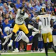 Pittsburgh Steelers tight end Darnell Washington hurdles Indianapolis Colts safety Nick Cross.
