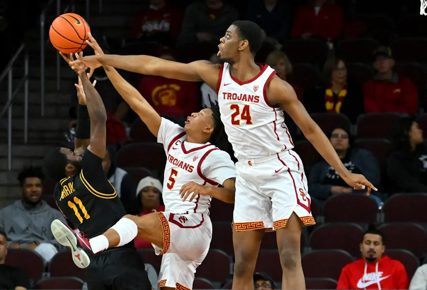 Boogie Ellis and Joshua Morgan of the USC Trojans defend against a shot by Joel Murray of the Long Beach State 49ers.