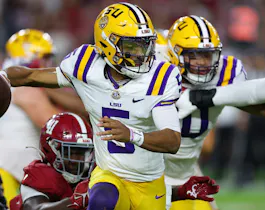 Jayden Daniels of the LSU Tigers breaks a tackle as he rushes away from Chris Braswell of the Alabama Crimson Tide during the second quarter at Bryant-Denny Stadium. Daniels is the favorite to go No. 2 by the 2024 NFL Draft odds.
